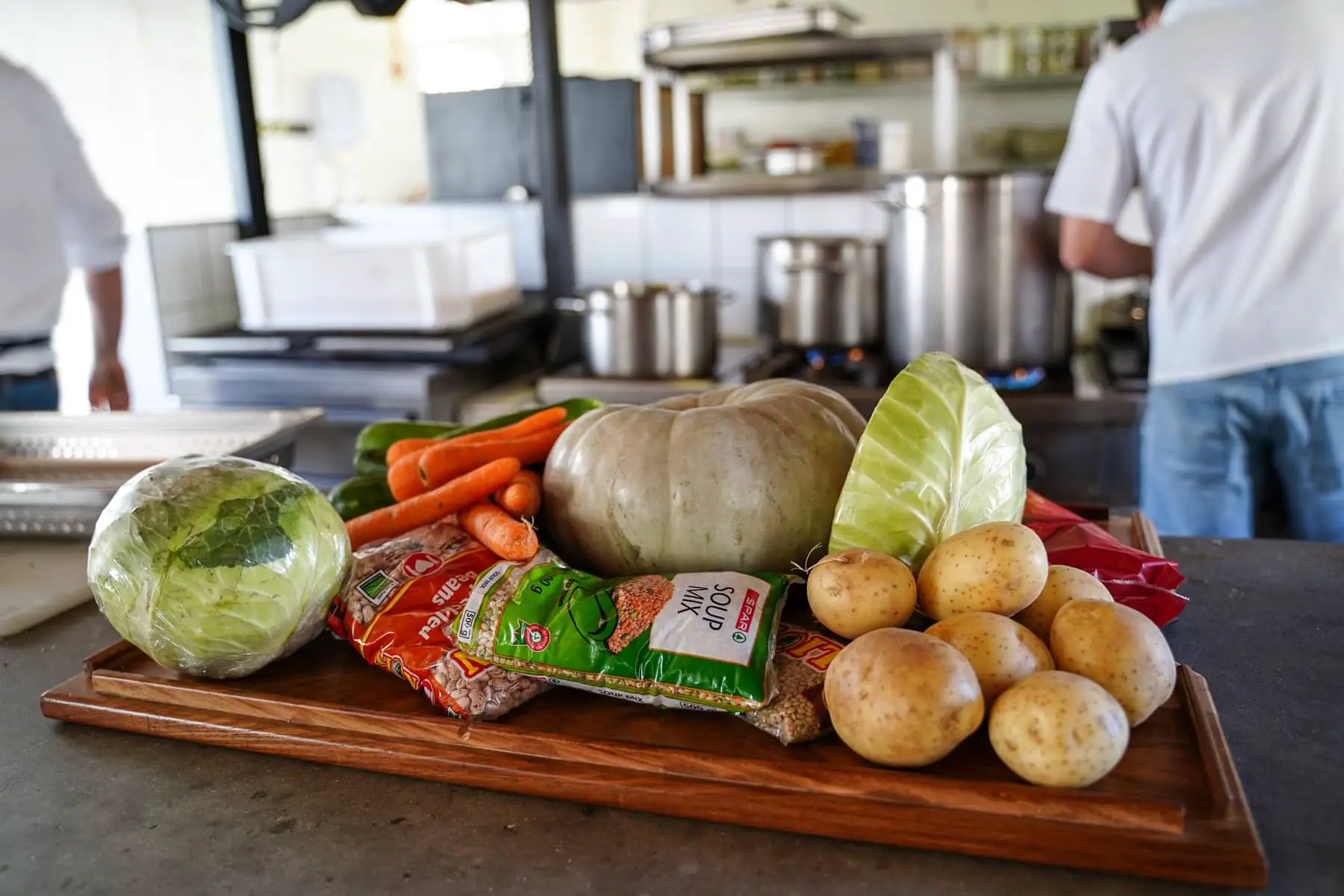 vegetables on kitchen table with chef in background